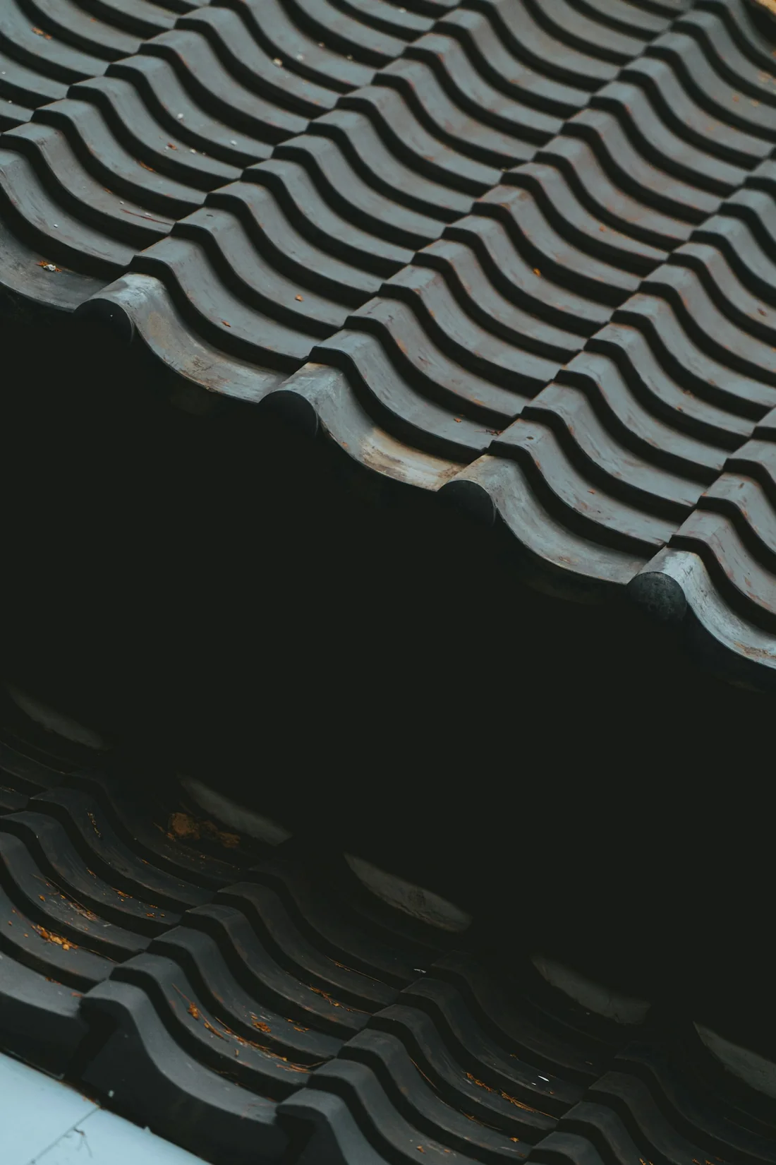 Detail einer präzise verlegten Dachdeckung im Streiflicht